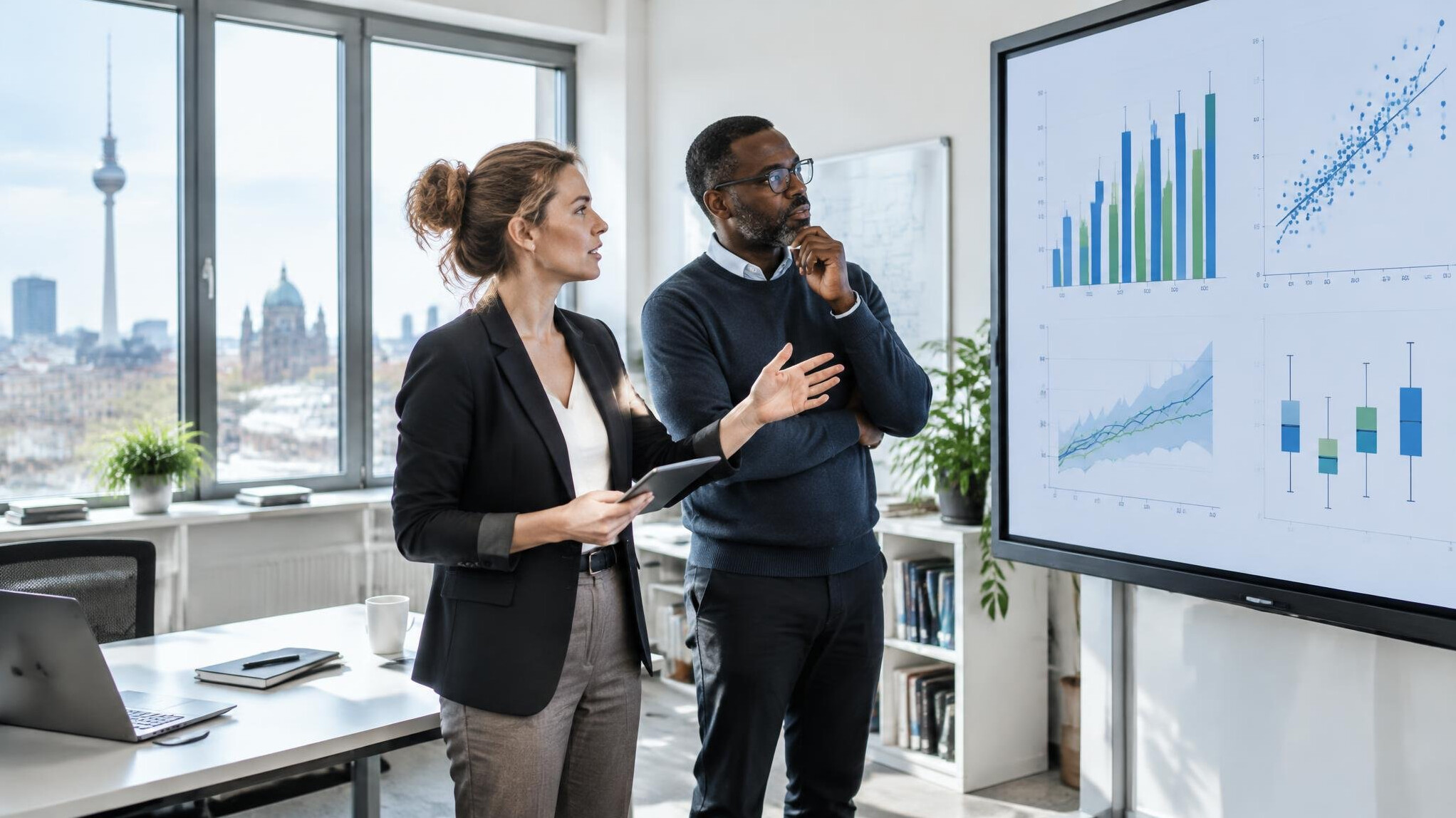 Researchers analyzing data charts on a large screen in a modern office
